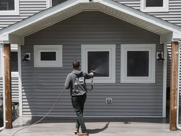 Jr pressure washing a house